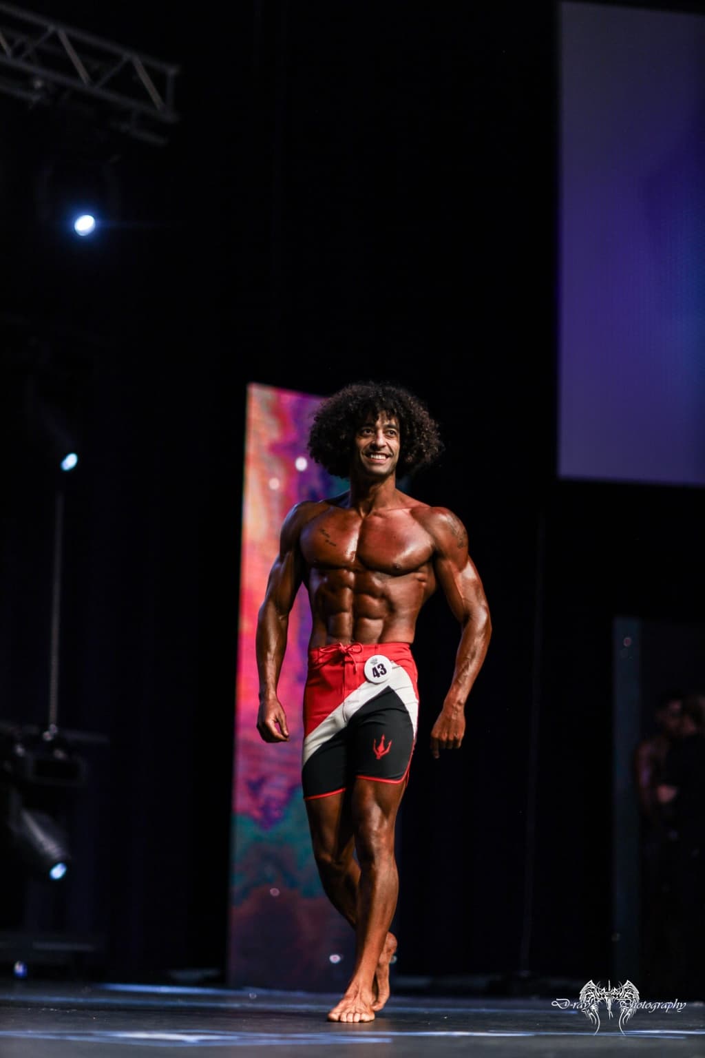 Ozzy walking on stage in red and black board shorts